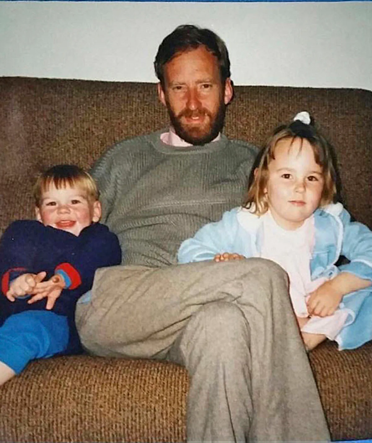 Callum smiles as a little boy while pictured on the couch with his dad and sister.