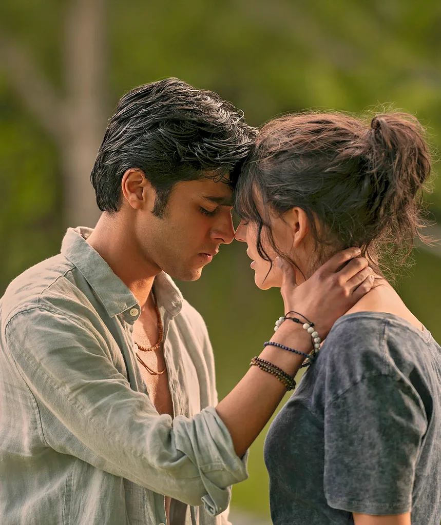 Gat holds his hand to Cadence's neck as they press their forehead together looking as if they are about to kiss.