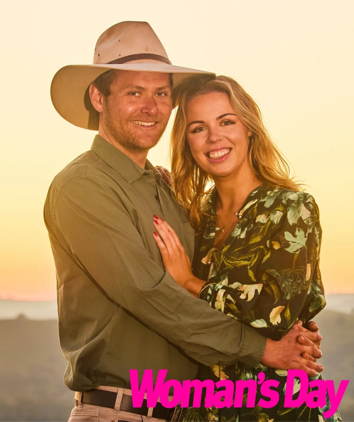 Tom and Georgie pose in front of a glowing yellow sunset.