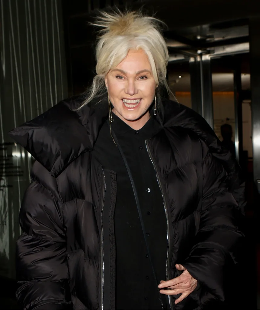 A blonde woman smiles.