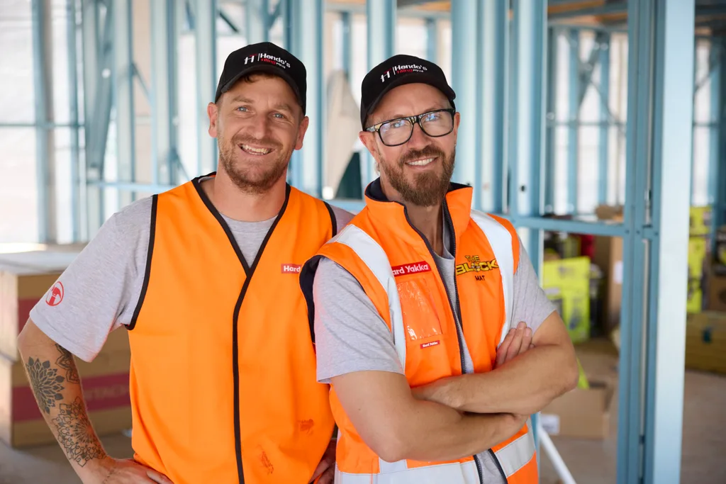 Mat and Robby on set of The Block wearing hi vis and caps.