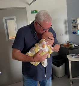 Scott Cam host of The Block kisses his granddaughter Tiggy in a hospital room.