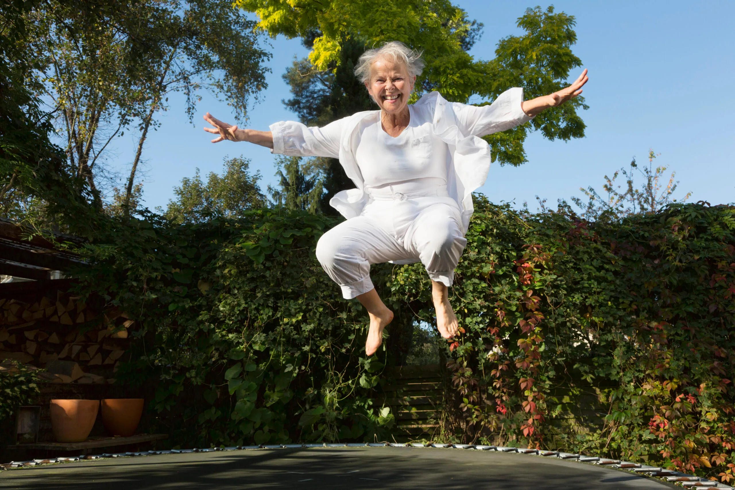 55-59 Years; 60s; Activity; Adult; Caucasian; Cheerful; Color Image; Exercising; Female; Formal Garden; Freedom; Full Length; Fun; Green Eyes; Happiness; Healthy Lifestyle; Horizontal; Jumping; Laughing; Leisure Activity; Lifestyles; One Person; One Senior Woman Only; One Woman Only; Only Mature Women; Only Senior Women; Only Women; Ornamental Garden; Outdoors; Overweight; People; Photography; Recreational Pursuit; Senior Adult; Senior Women; Short Hair; Sport; Trampoline; Vitality; White Hair; Women;