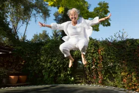 55-59 Years; 60s; Activity; Adult; Caucasian; Cheerful; Color Image; Exercising; Female; Formal Garden; Freedom; Full Length; Fun; Green Eyes; Happiness; Healthy Lifestyle; Horizontal; Jumping; Laughing; Leisure Activity; Lifestyles; One Person; One Senior Woman Only; One Woman Only; Only Mature Women; Only Senior Women; Only Women; Ornamental Garden; Outdoors; Overweight; People; Photography; Recreational Pursuit; Senior Adult; Senior Women; Short Hair; Sport; Trampoline; Vitality; White Hair; Women;