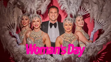 A man surrounded by women dressed as showgirls
