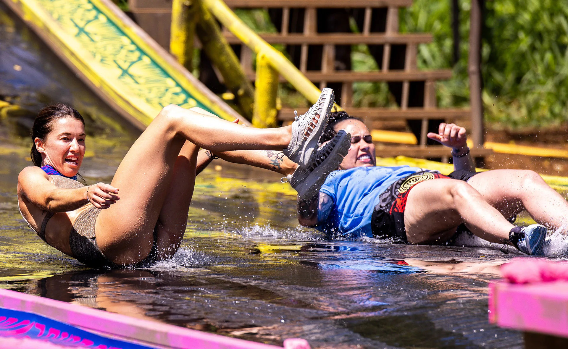 Parvati and Kirby come down a slide as part of a challenge on Survivor