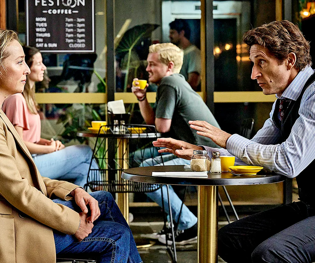 Jonathan sites opposite Asher Keddie in a coffee shop, in a scene from Strife.