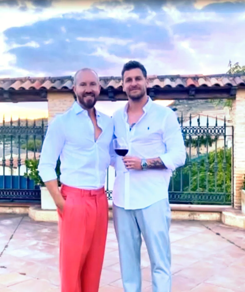 Mat and Robby posing for a photo in front of a house.