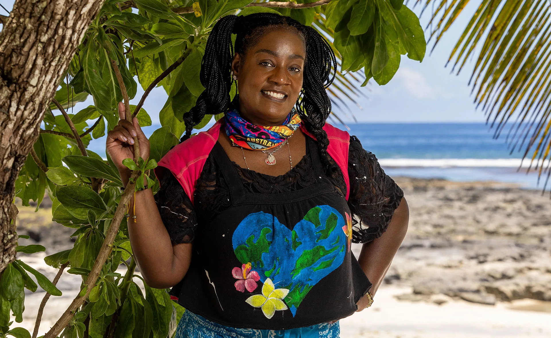 Cirie stands, with her hands on her hips, on a beach in Samoa.