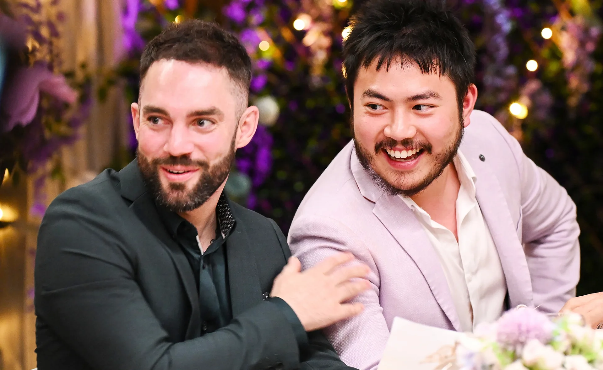 Mark taps Tan on the shoulder as they sit at the table on My Kitchen Rules