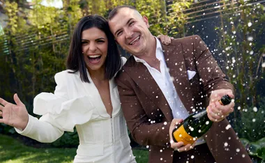 Steph and Gian winners of the 2023 series of The Block celebrating by spraying a bottle of Veuve.