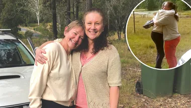 Two women smile and hug.