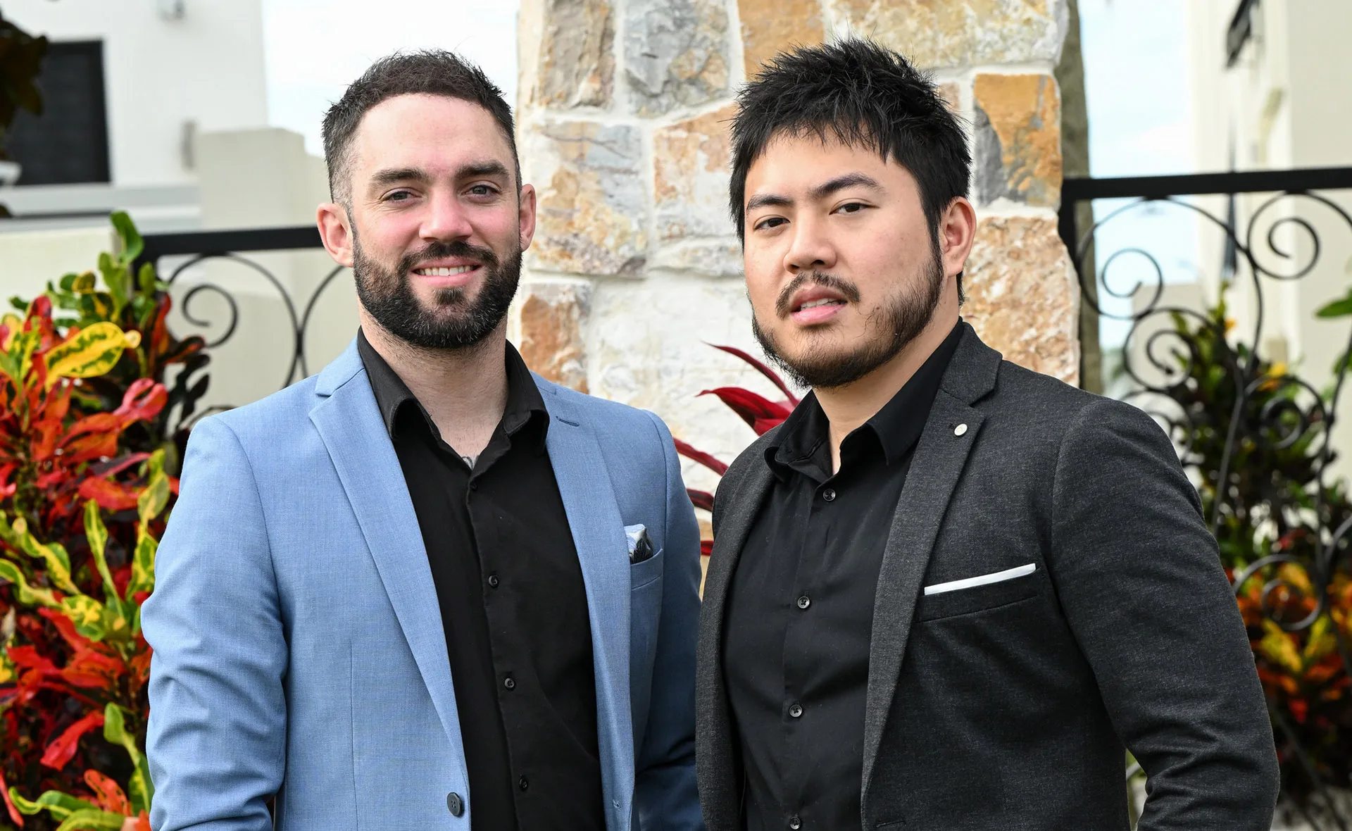 Mark, in a blue jacket, and Tan, in a black jacket, stand outside