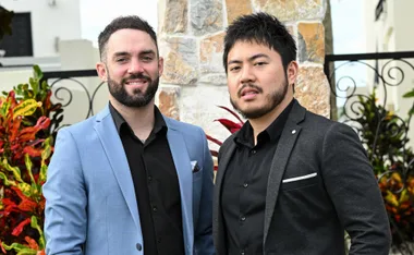 Mark, in a blue jacket, and Tan, in a black jacket, stand outside