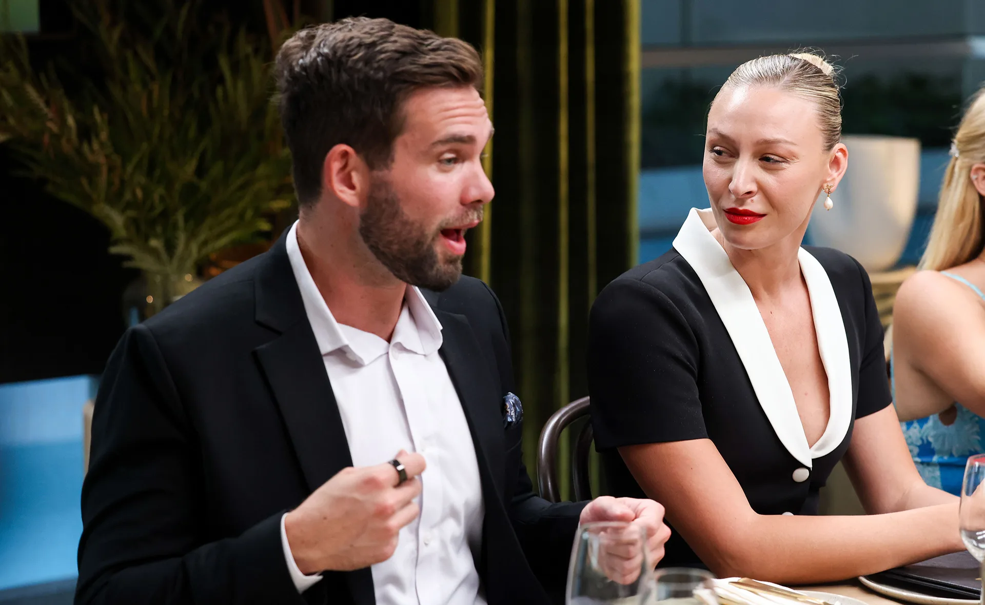 Sitting at an instant restaurant on My Kitchen Rules, Michael is speaking and Rielli is looking at him