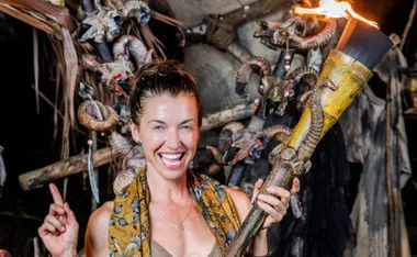 Parvati smiles, holding her torch, after winning Survivor