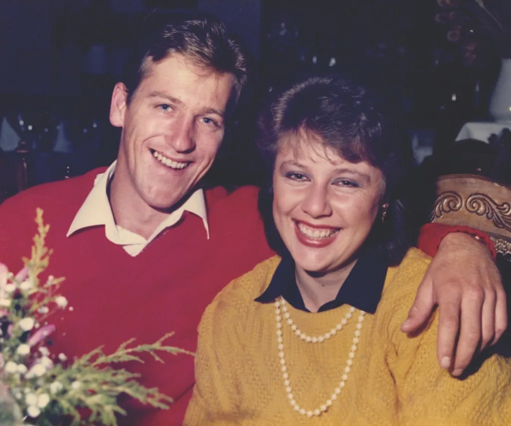 A man and a woman smile to camera.