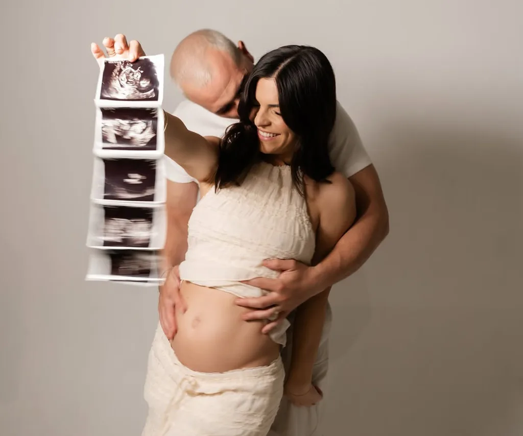 Steph and Gian hold up an ultrasound of their daughter when announcing their pregnancy to social media.