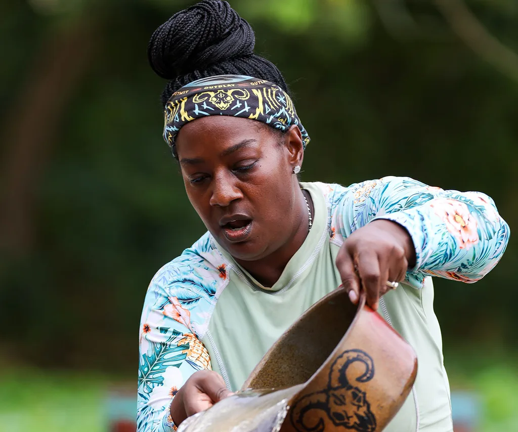 Cirie tips water out of a container during a challenge on Survivor.
