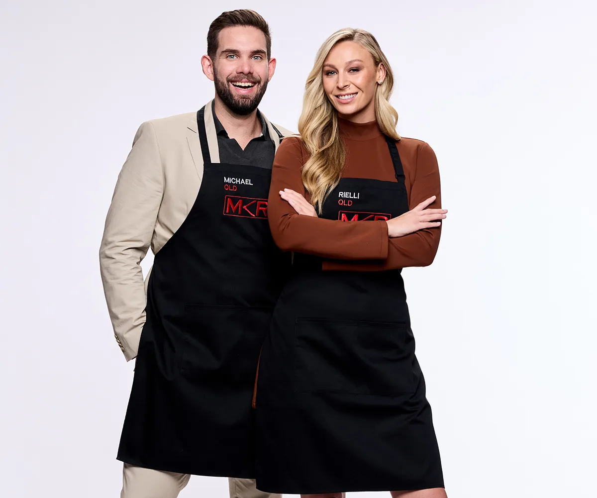 Michael and Rielli, wearing their MKR aprons, stand next to each other