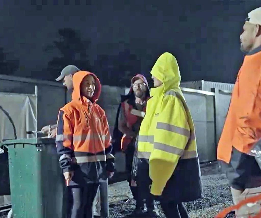 Alicia and Britt both in hooded tradie clothes confronting each other outside The Block.