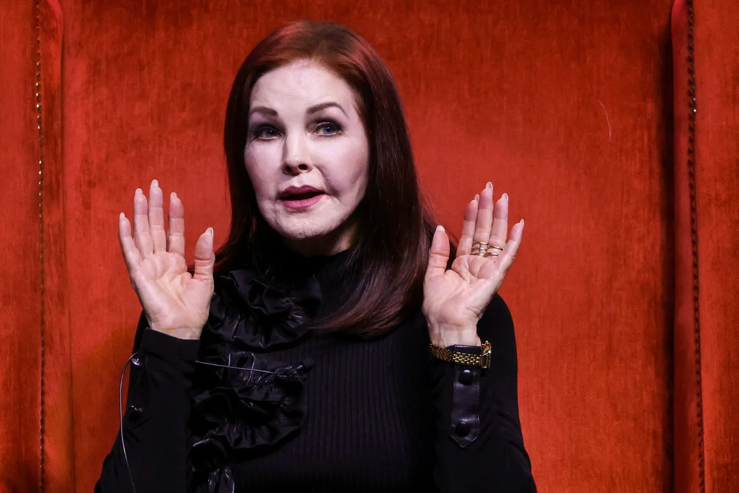 Priscilla Presley with her hands in the air