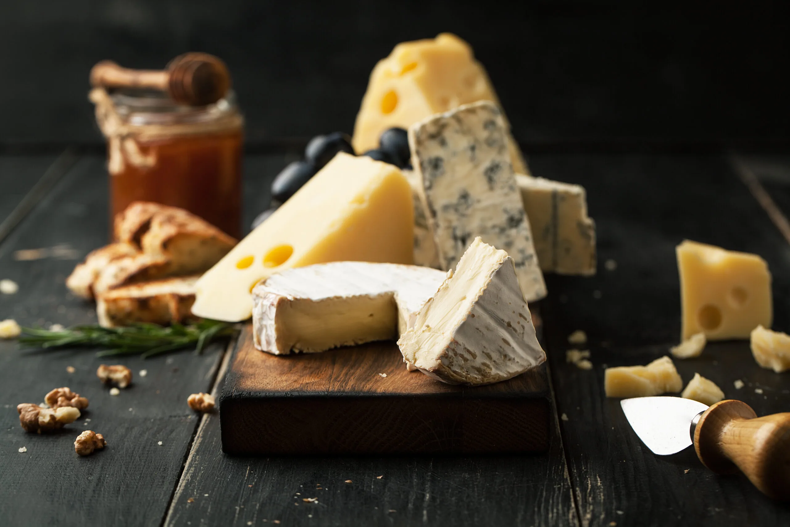 A variety of cheeses on a wooden block.