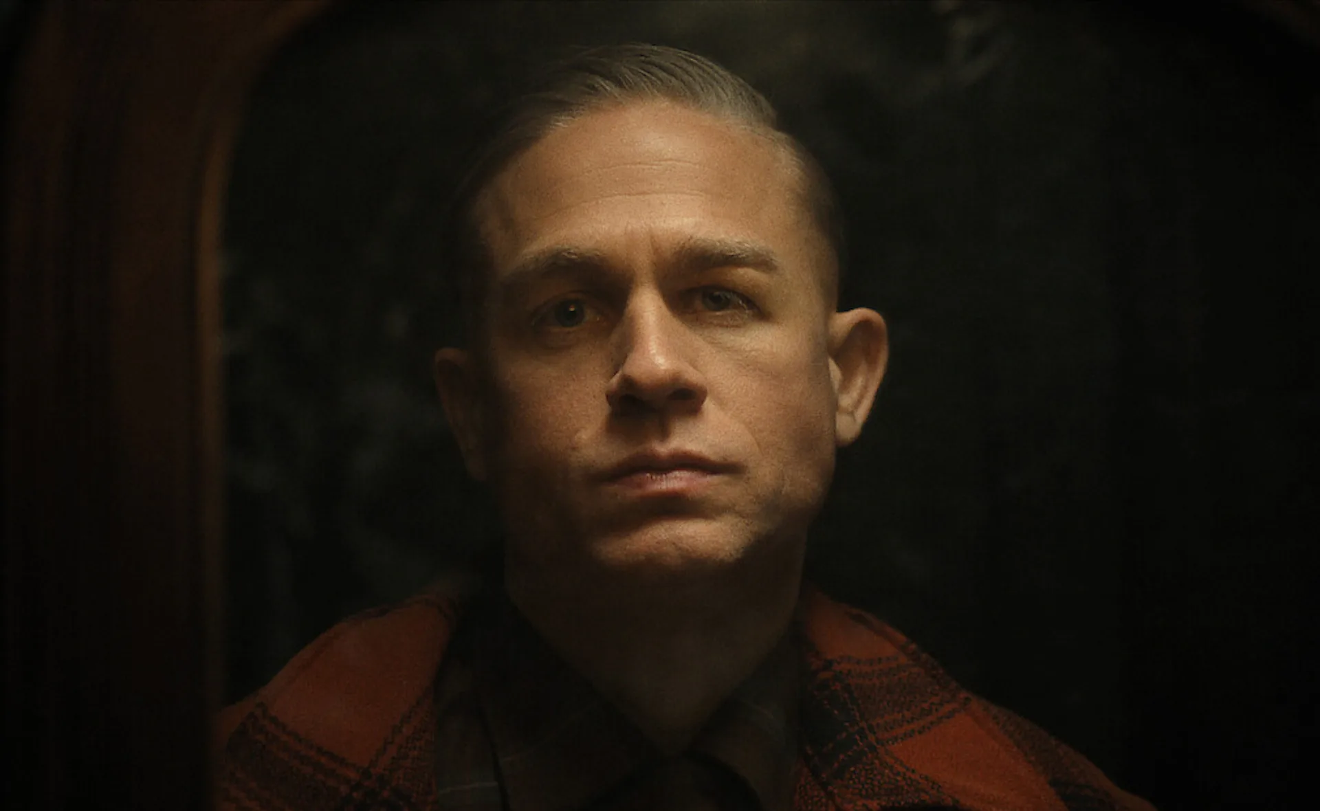 An actor playing Ed Gein stares at the camera