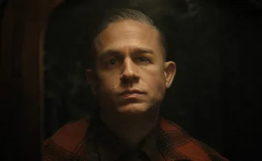 An actor playing Ed Gein stares at the camera