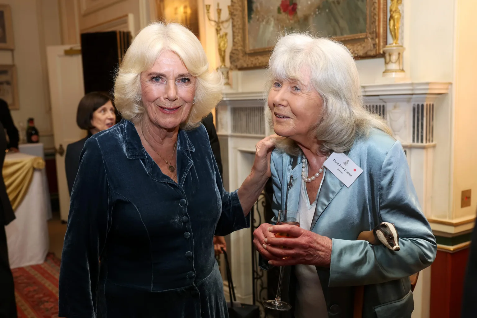 Queen Camilla and Jilly Cooper pose during a reception to mark the launch of the Queen's reading room medal at Clarence House on March 25, 2025 in London, England. Queen Camilla, accompanied by King Charles III, The Duchess of Gloucester, and distinguished authors along with members of the literary community, came together to celebrate the continued efforts of The Queen's Reading Room and its mission to inspire greater reading among people.