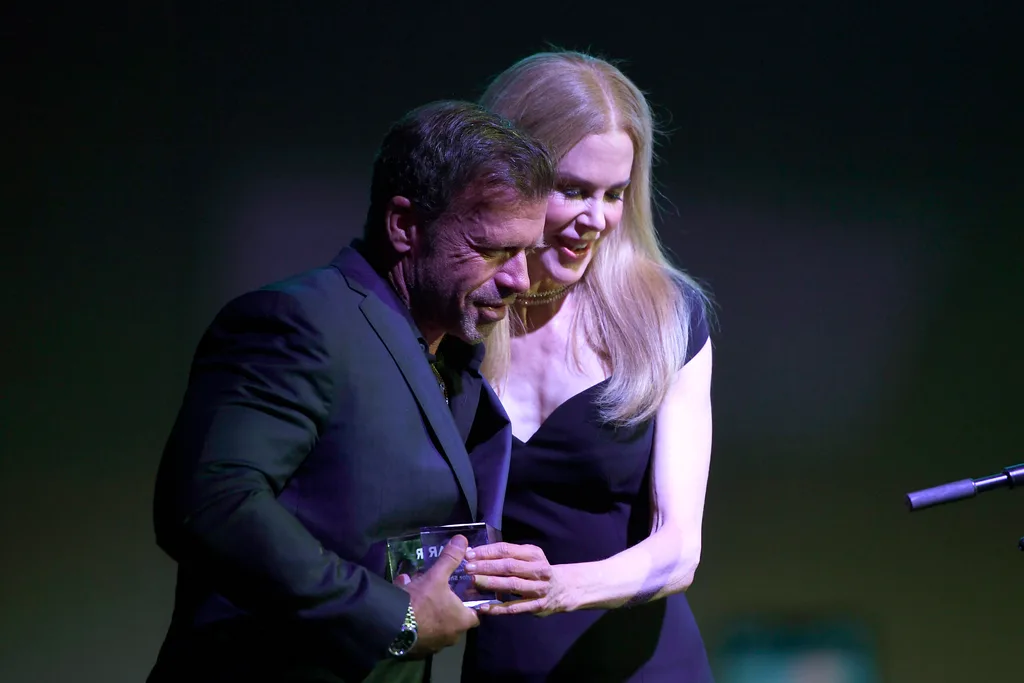 Taylor Sheridan and Nicole Kidman speak onstage during the amfAR Dallas Gala.