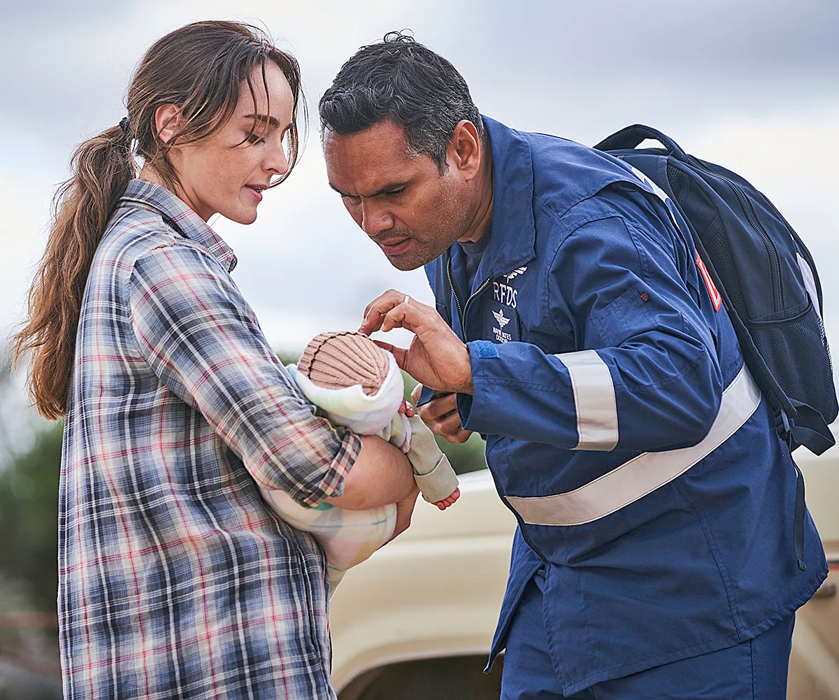Julie and Wayne hold a baby on set of RFDS.