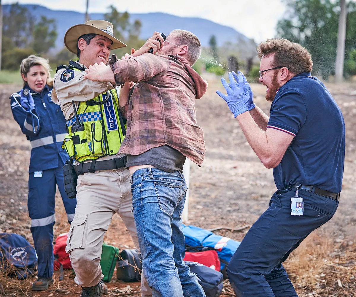 Caleb gets Matty with the mace spray in a struggle on set of RFDS.