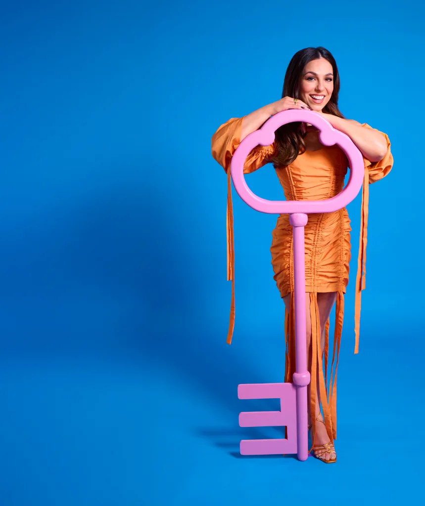 Mel Tracina holding a giant pink key to the Big Brother 2025 house.