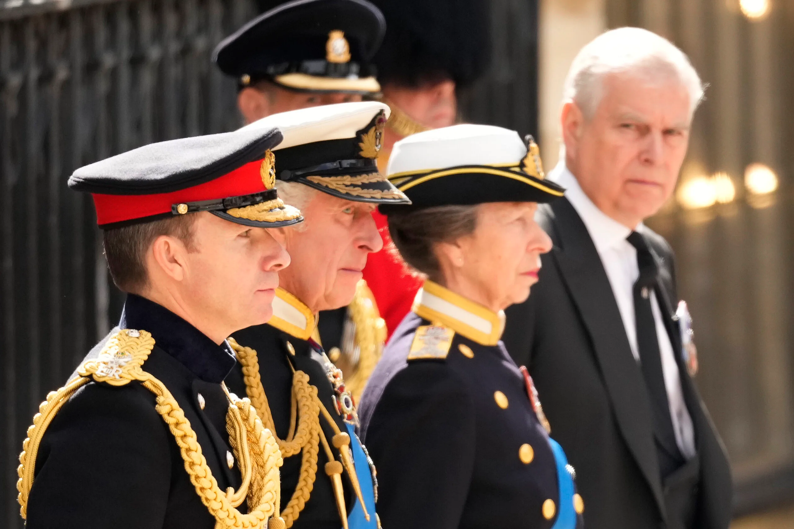 King Charles III, Anne, Princess Royal and Prince Andrew, Duke of York watch on as The Queen's funeral cortege borne on the State Gun Carriage of the Royal Navy as it departs Westminster Abbey on September 19, 2022 in London, England. 