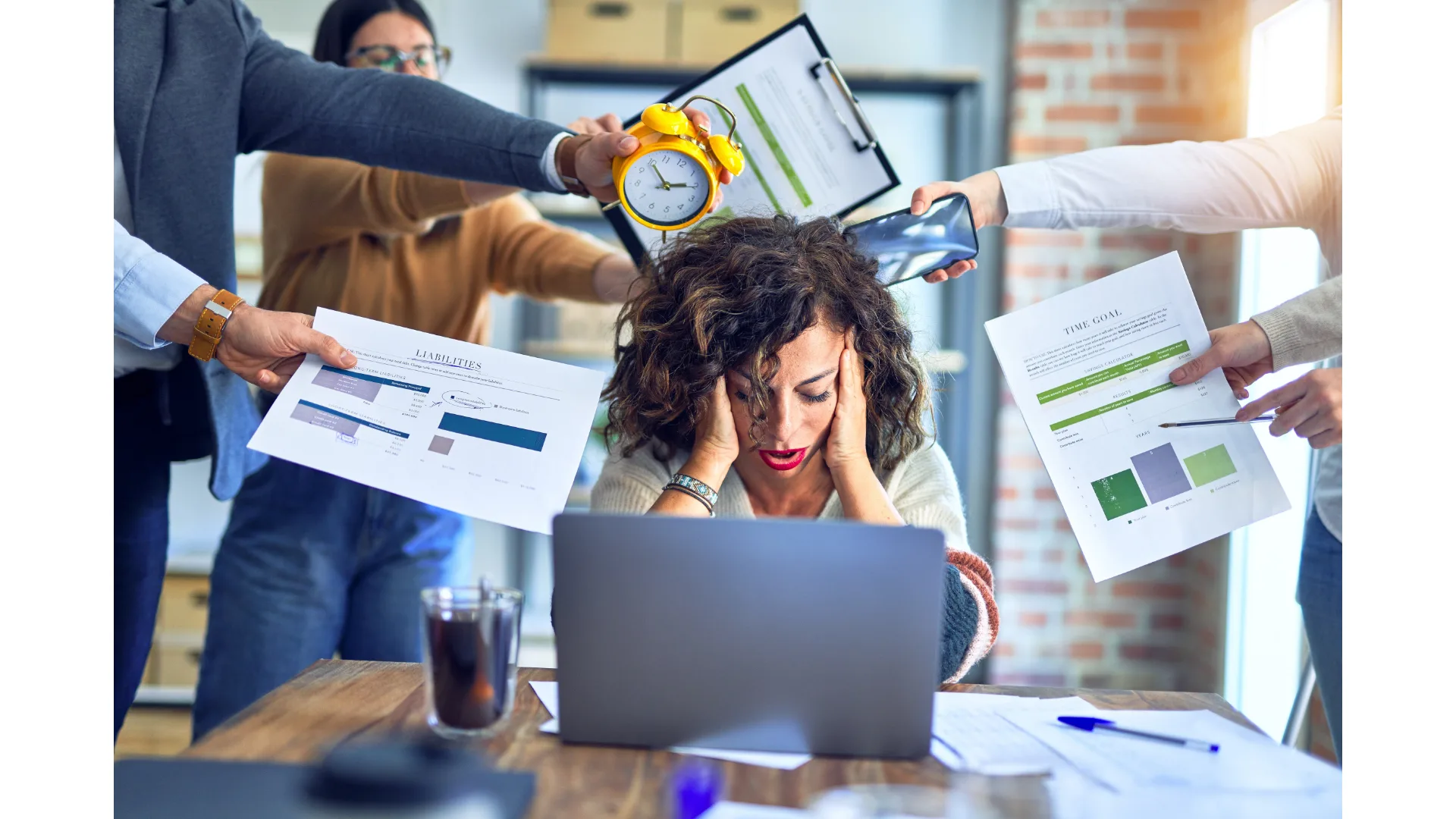 A woman appears stressed out at work, as people hold things for her to action.