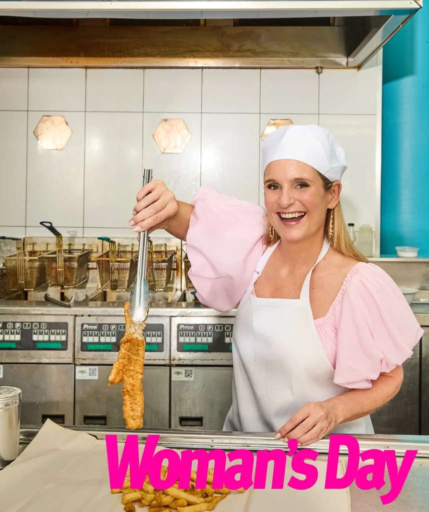 A woman in a kitchen wearing a chef's hat.