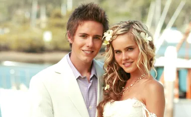 Robbie (Jason Smith) and Tasha (Isabel Lucas) marry in a 2006 Home and Away wedding. Pictured in front of a boat and water.