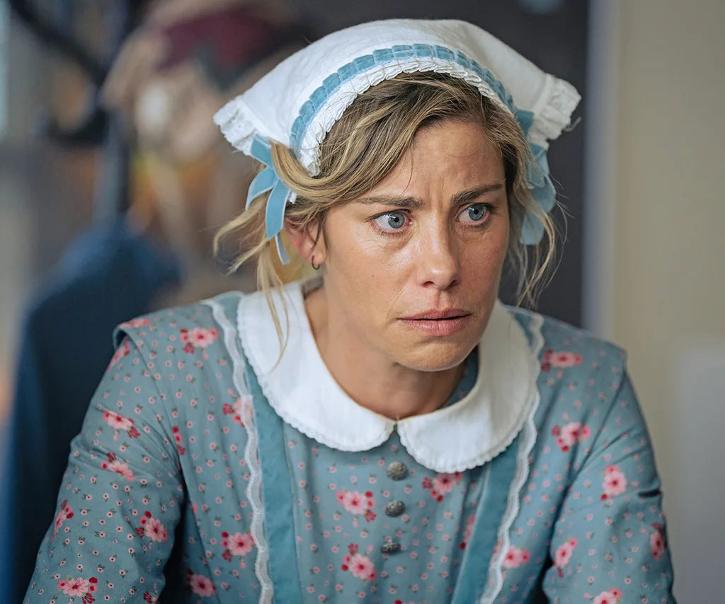 Brooke Satchwell, wearing a bonnet and an old-style dress, has a concerned look on her face
