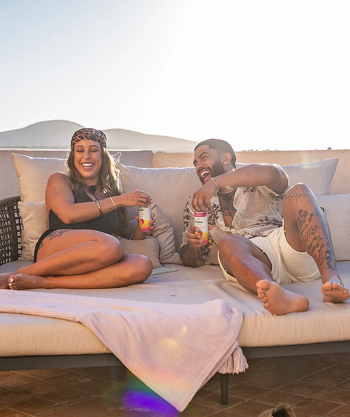 Yana and Dylan on a sunbed tanning with drinks in their hand on Love Island Australia 2025.