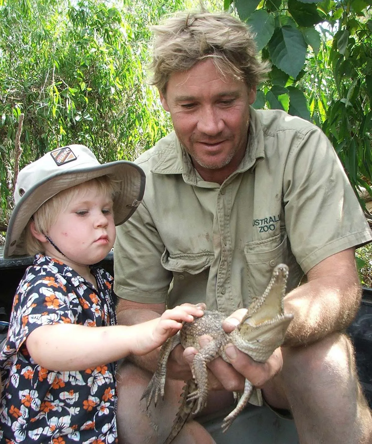 Robert Irwin with his father, Steve Irwin, holding a lizard.