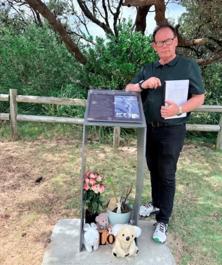 A man stands a memorial.