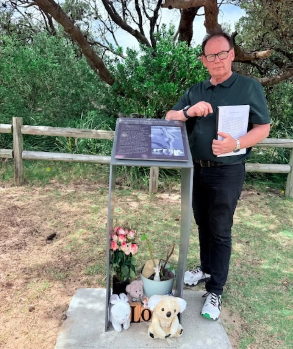 A man stands a memorial.