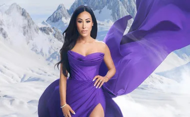 Angie K poses for a gallery shot in a purple dress against a snow drenched mountain for Real Housewives of Salt Lake City