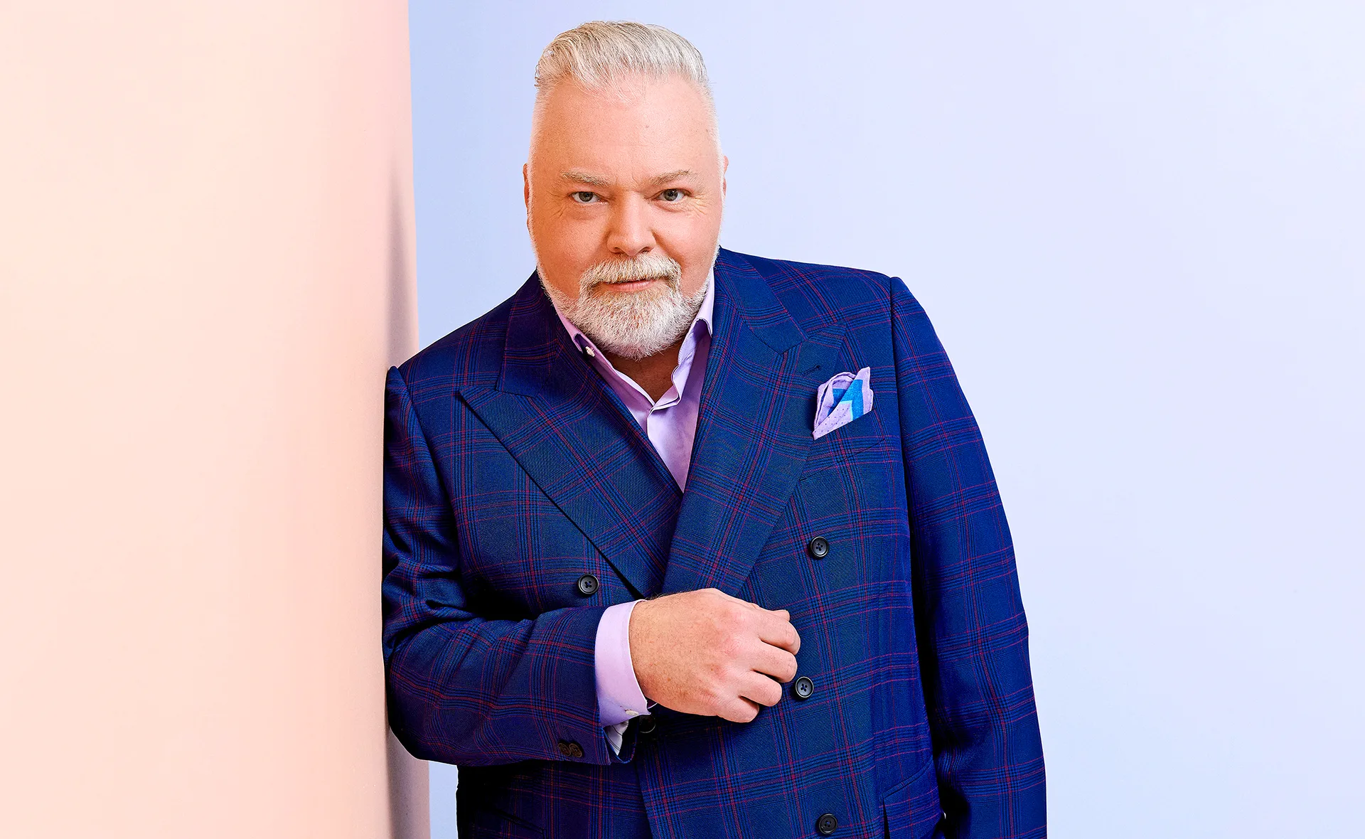Kyle Sandilands in a suit poses for a promotional shot for Australian Idol.