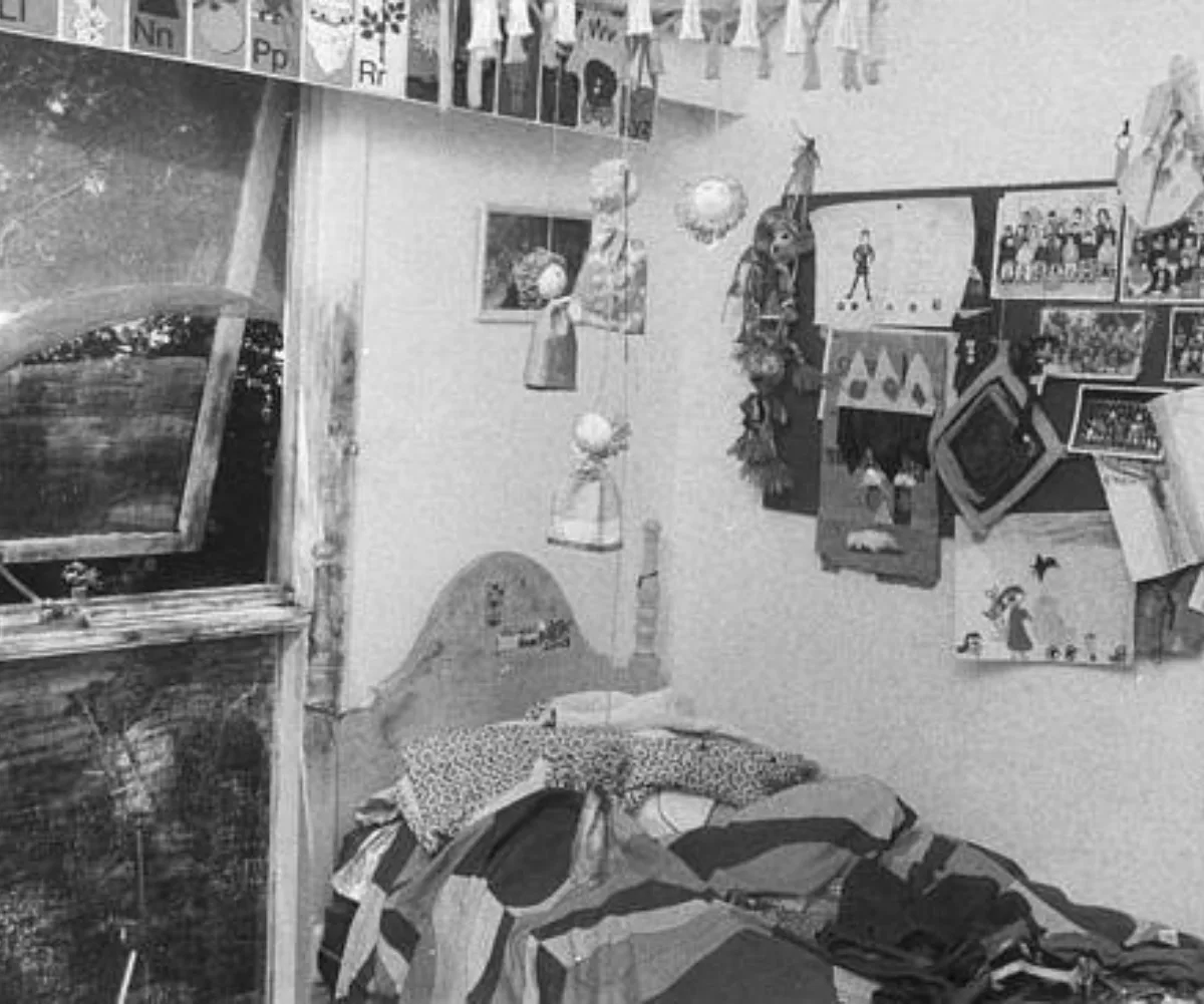 A black and white image of a bed room with an open window