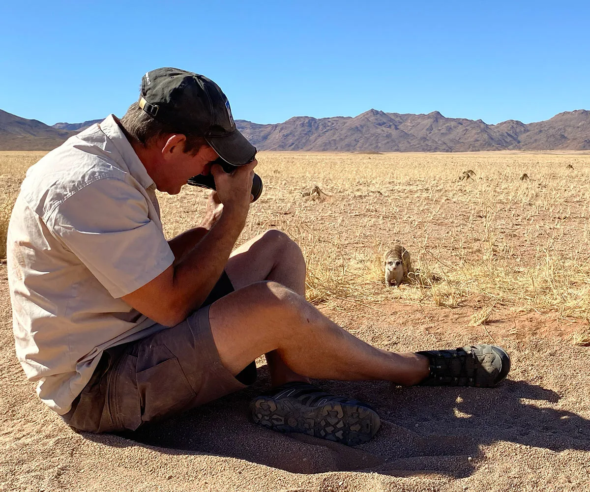 Lars photographing a meerkat while camping in Namibia 2023. (Image: Supplied)