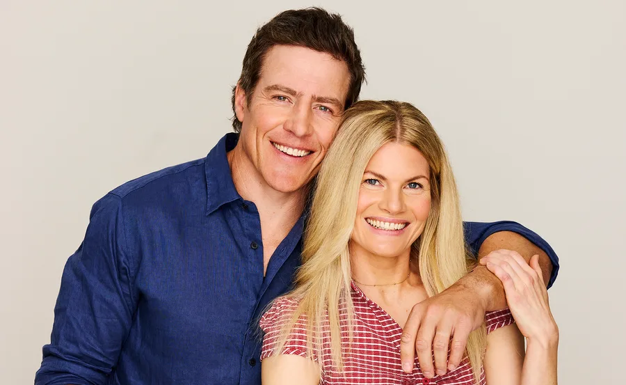 Stephen Peacocke, in a blue shirt, stands with his arm around Bonnie Sveen's shoulders