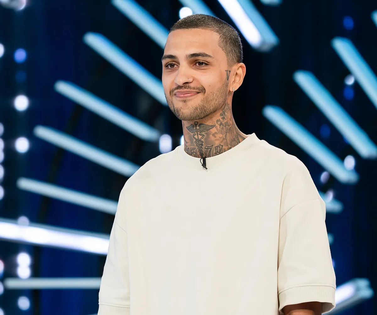 Tre, dressed in white, stands on the Australian Idol audition stage.