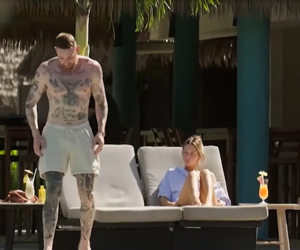 Bec on a sun lounge as Danny walks off towards the ocean in his boardies after a tense conversation.